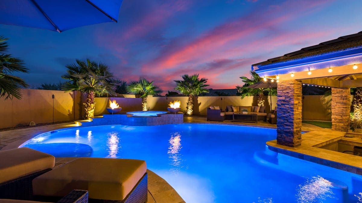Illuminated Houston backyard pool and deck at night