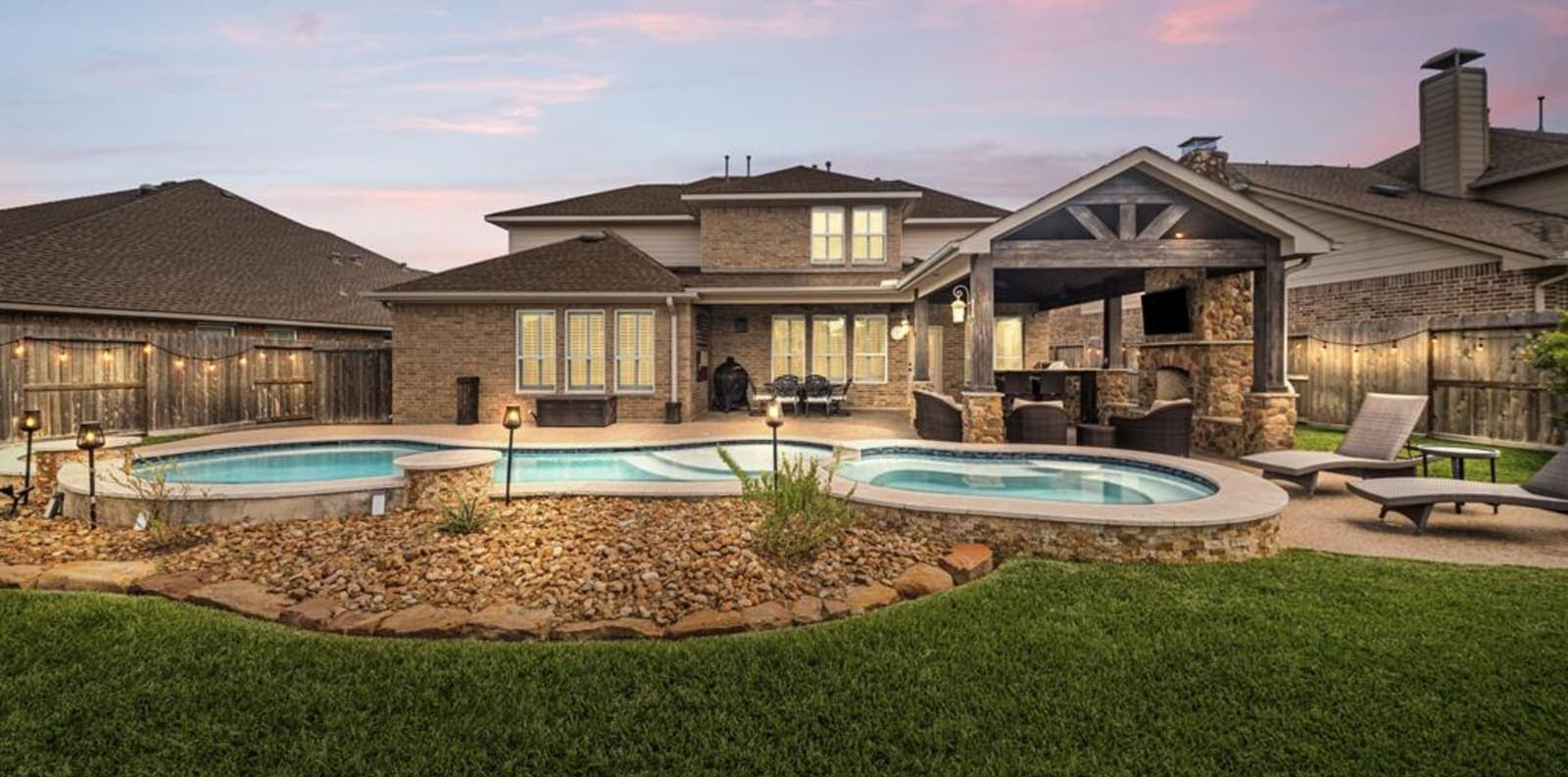 Backyard pool and covered patio at twilight