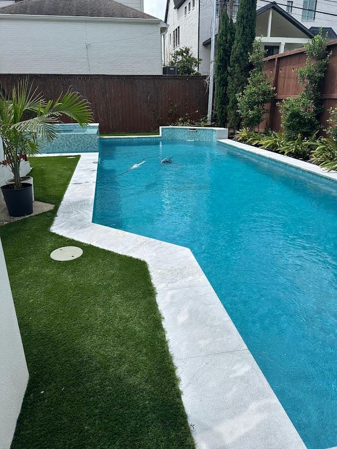 Raised spa with glass tile spilling into the pool