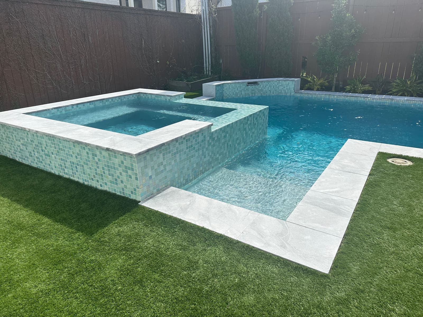 Pool and raised spa with tile spillway