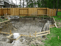 Grid of steel reinforcement bar tied on 8-inch centers throughout the pool shell