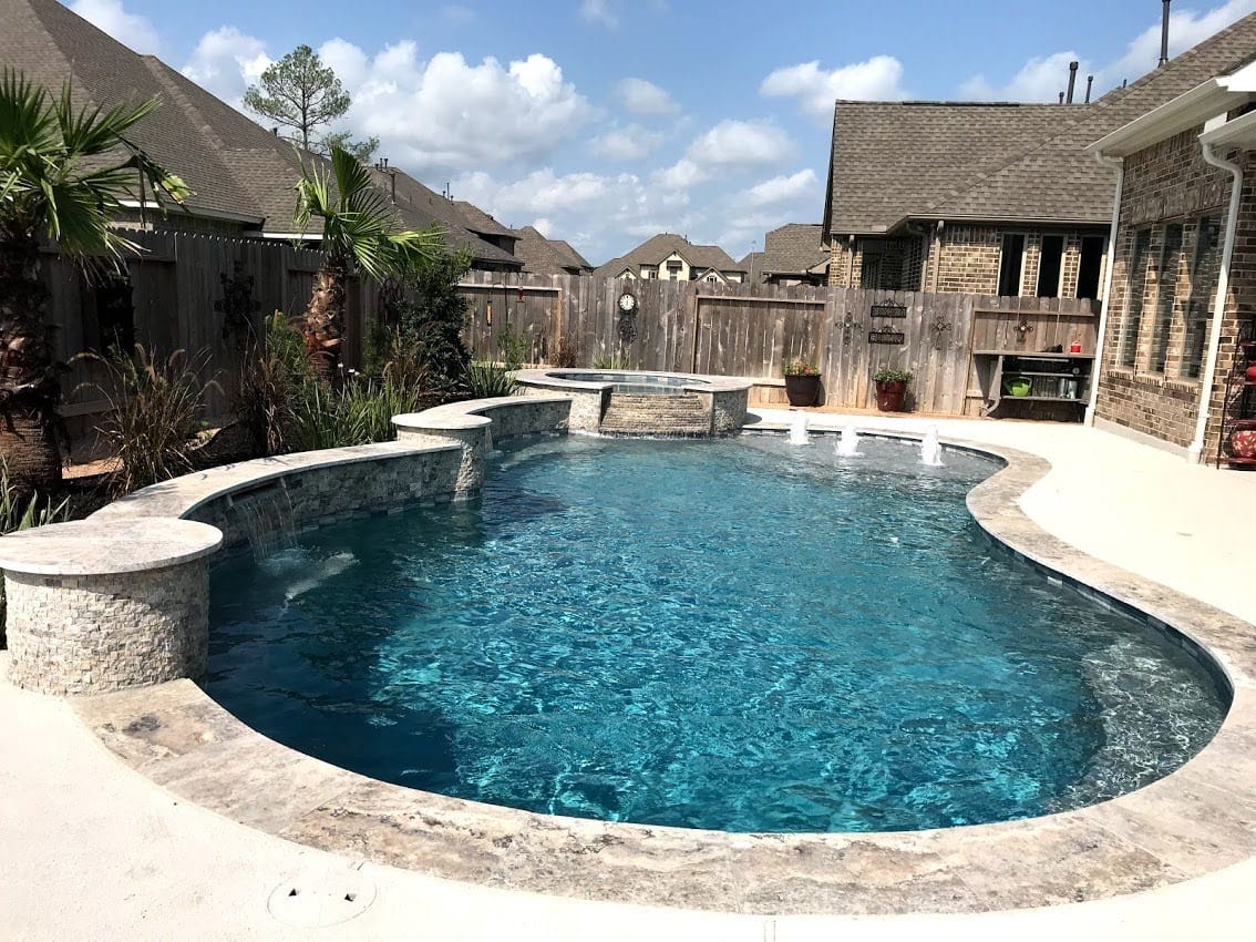 Free form pool by Houston Cool Pools - kidney-shaped pool with raised spa and bubblers