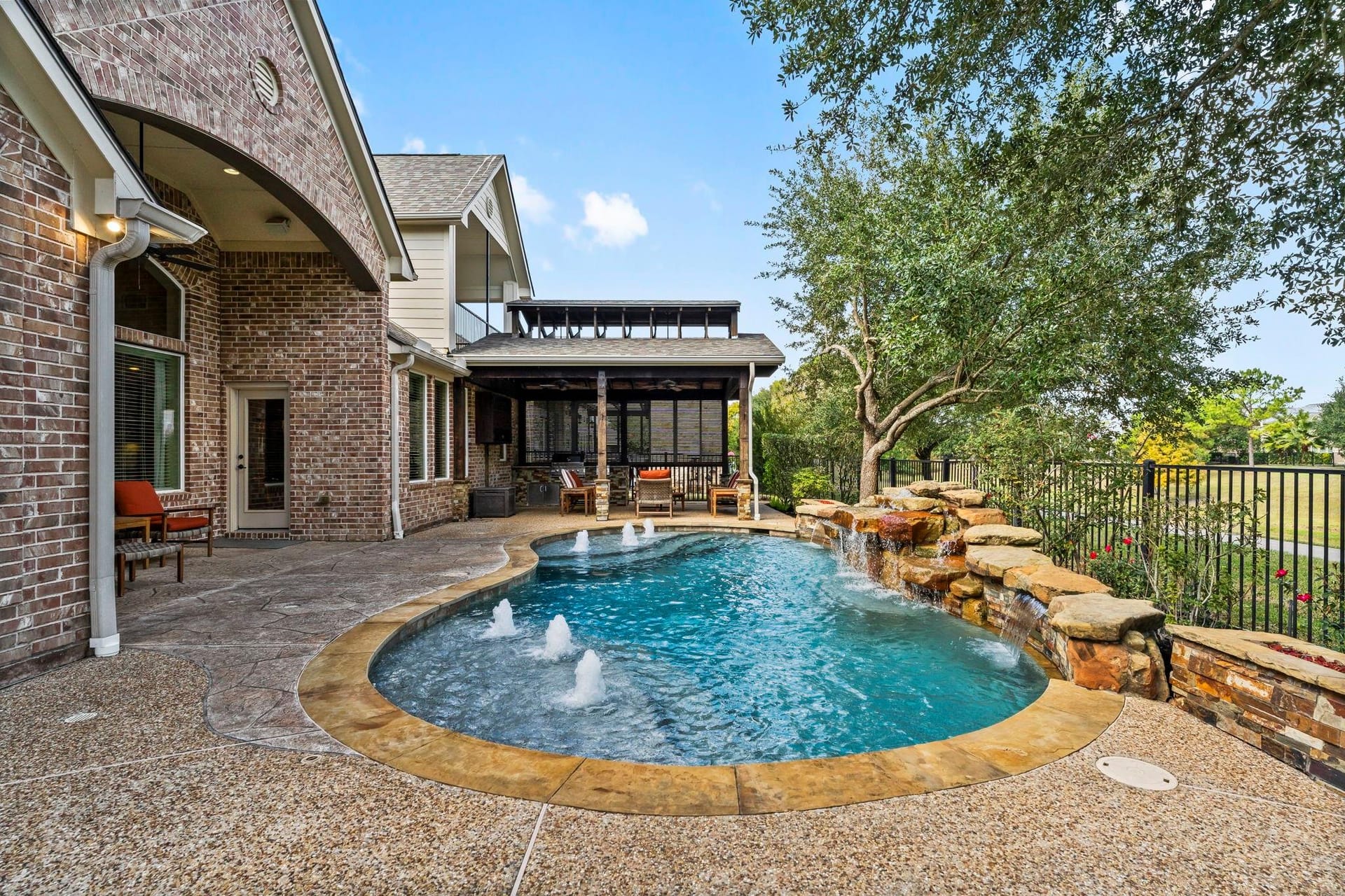 Free form pool by Houston Cool Pools - curved cove pool with bubblers and rock waterfall