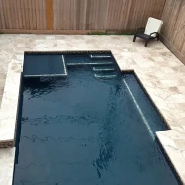 Geometric pool by Houston Cool Pools - dark-finish rectangular pool with tanning ledge