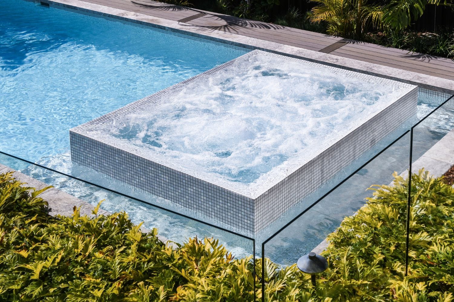 Geometric pool by Houston Cool Pools - rectangular pool with raised glass-mosaic spa
