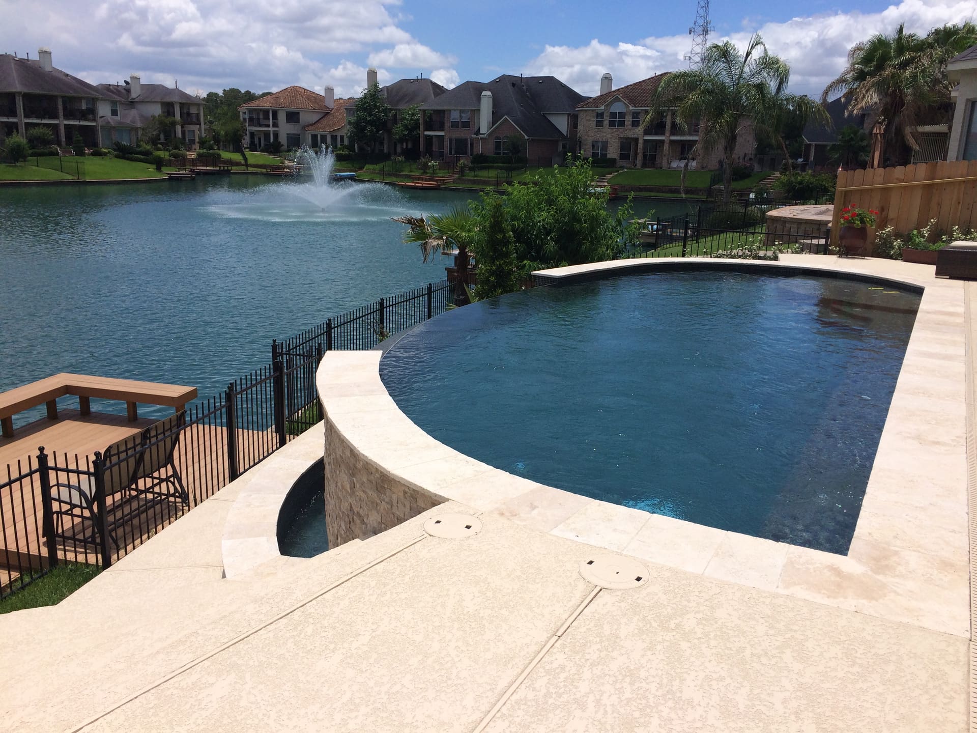 Free form pool by Houston Cool Pools - curved lakefront pool with raised spa