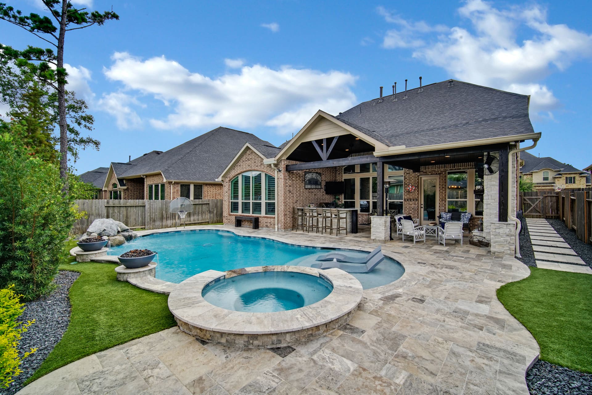 Free form pool by Houston Cool Pools - kidney-shaped pool with round spa and fire bowls