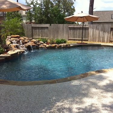 Free form pool by Houston Cool Pools - curved pool with rock waterfall