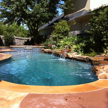 Free form pool by Houston Cool Pools - curved pool with rock waterfall
